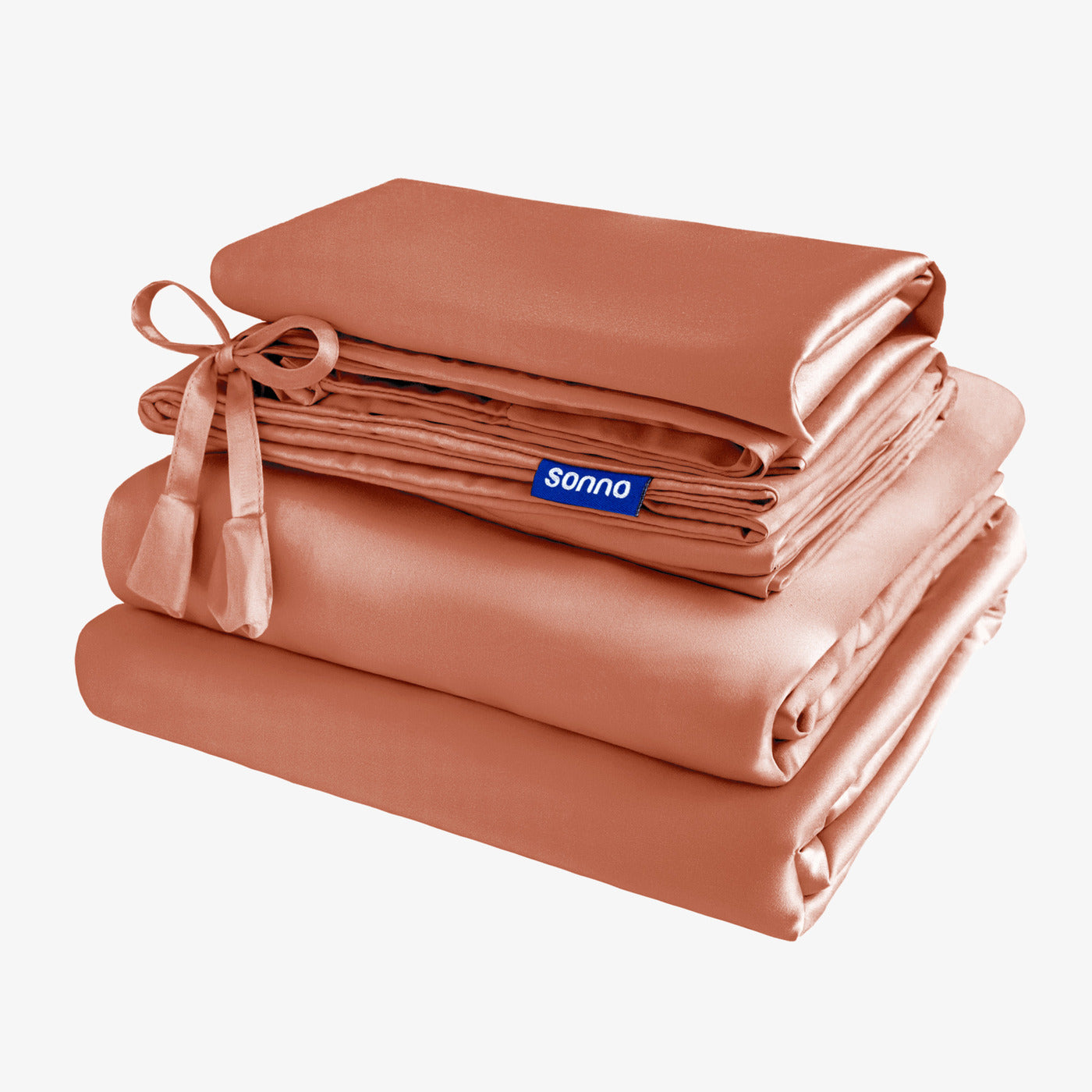 A neatly arranged stack of Sonno premium sheets in a warm terracotta colour, featuring a decorative ribbon. The soft, luxurious fabric is displayed against a clean white background, highlighting the quality and elegance of the sheets.