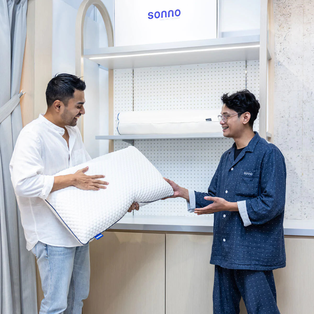 A customer holding a Sonno pillow and asking help to the sales assistant at Sonno Flagship Store in Publika, Kuala Lumpur, Malaysia