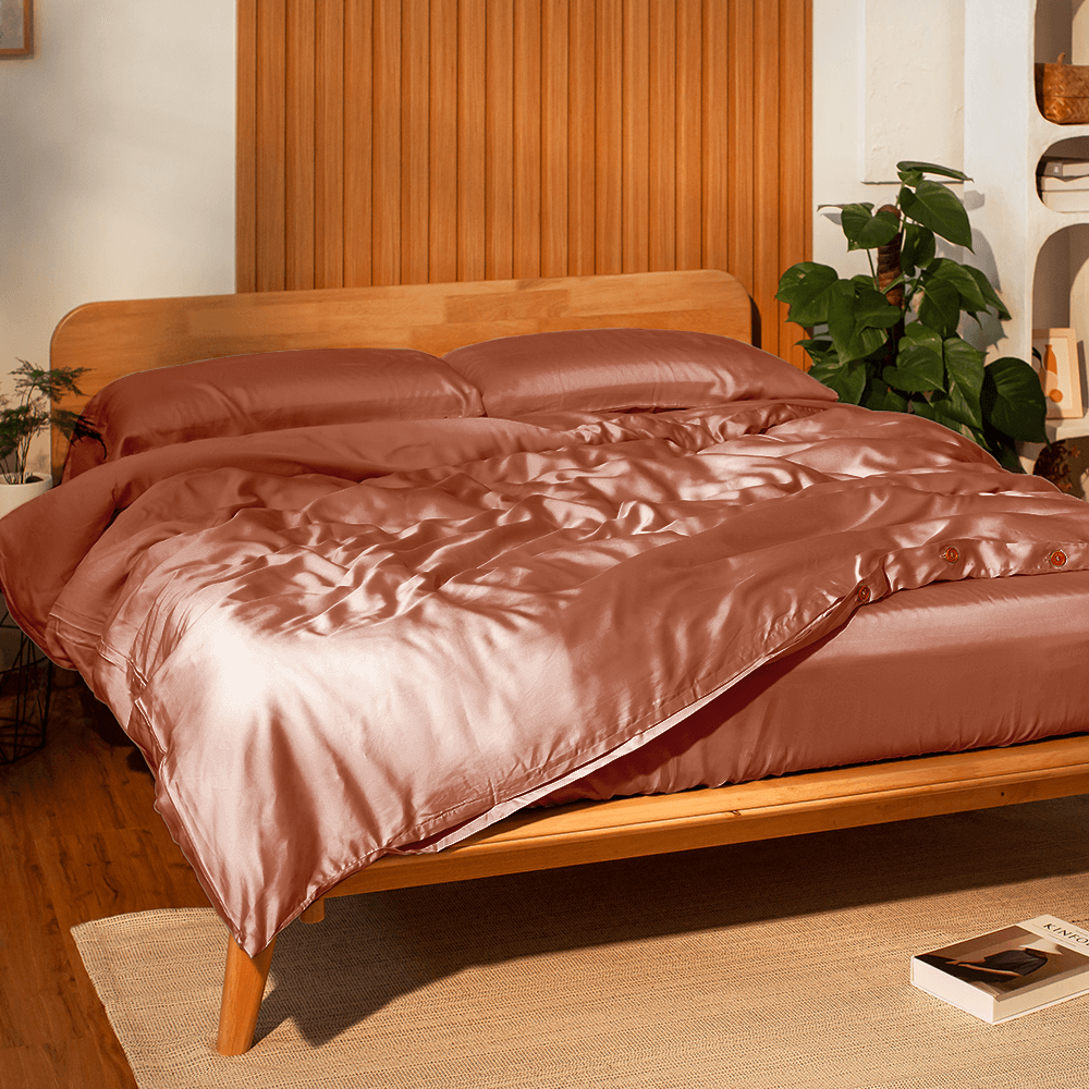 Sonno Tencel bed sheets on wooden bed frame, showcasing luxurious, eco-friendly fabric in a cozy bedroom setting.