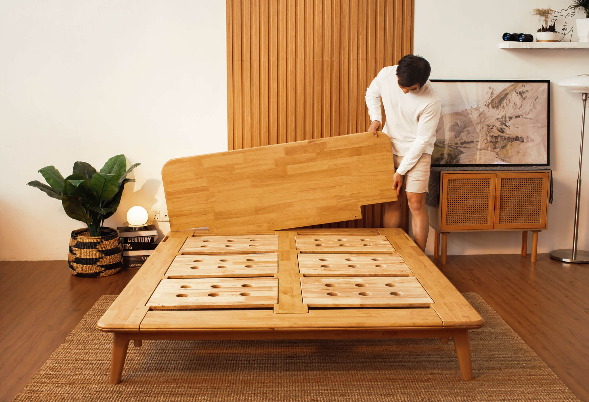 Man assembling the Sonno Signature Bed Frame in a Japandi bedroom