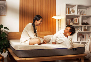 Man and Woman talking on the Sonno Signature Bed frame in a Japandi bedroom
