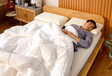 Man sleeping under the Sonno Duvet in a Japandi bedroom