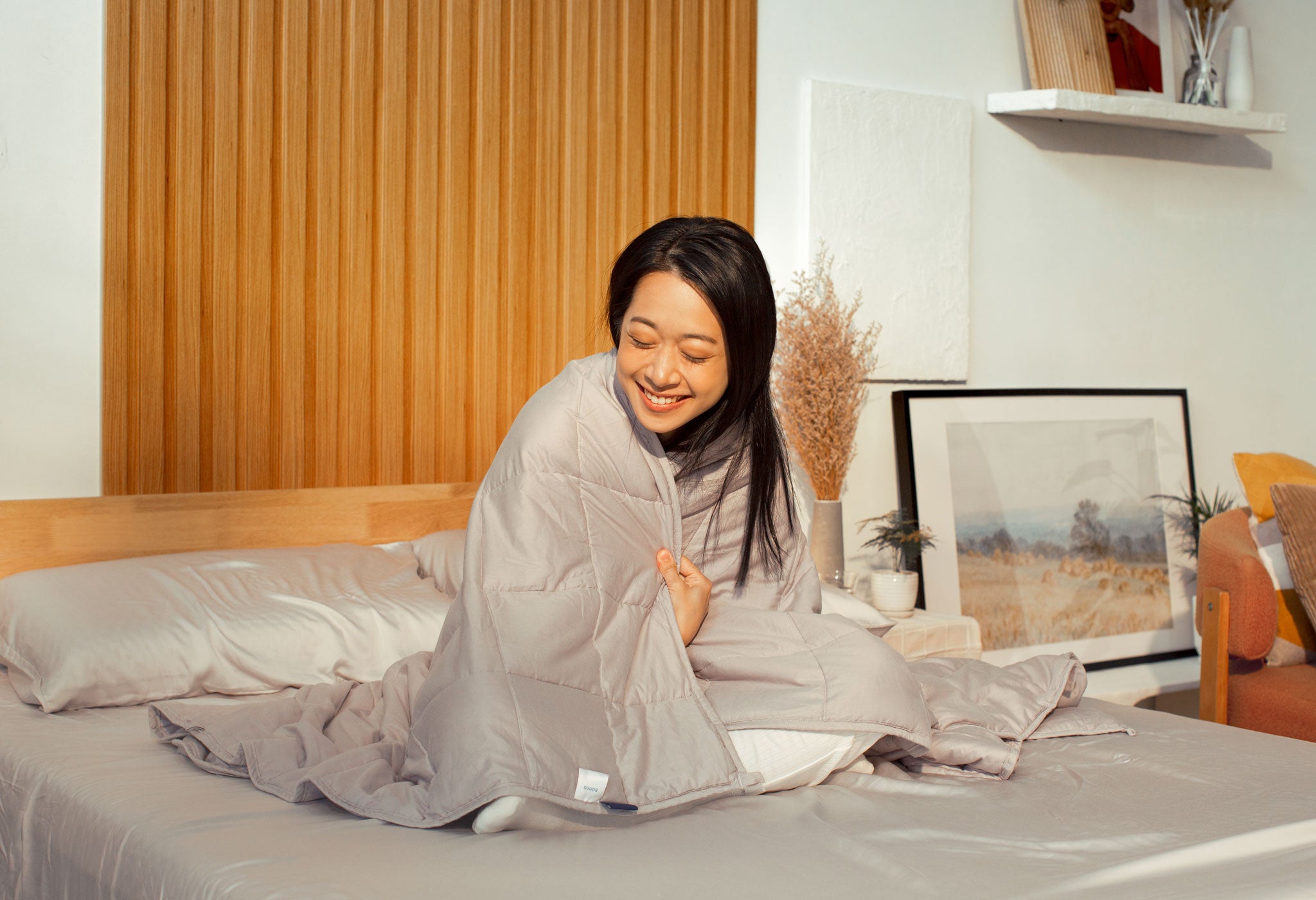 Content woman hugging the Sonno Huggy Blanket 