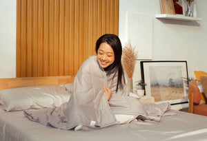 Content woman hugging the Sonno Huggy Blanket 