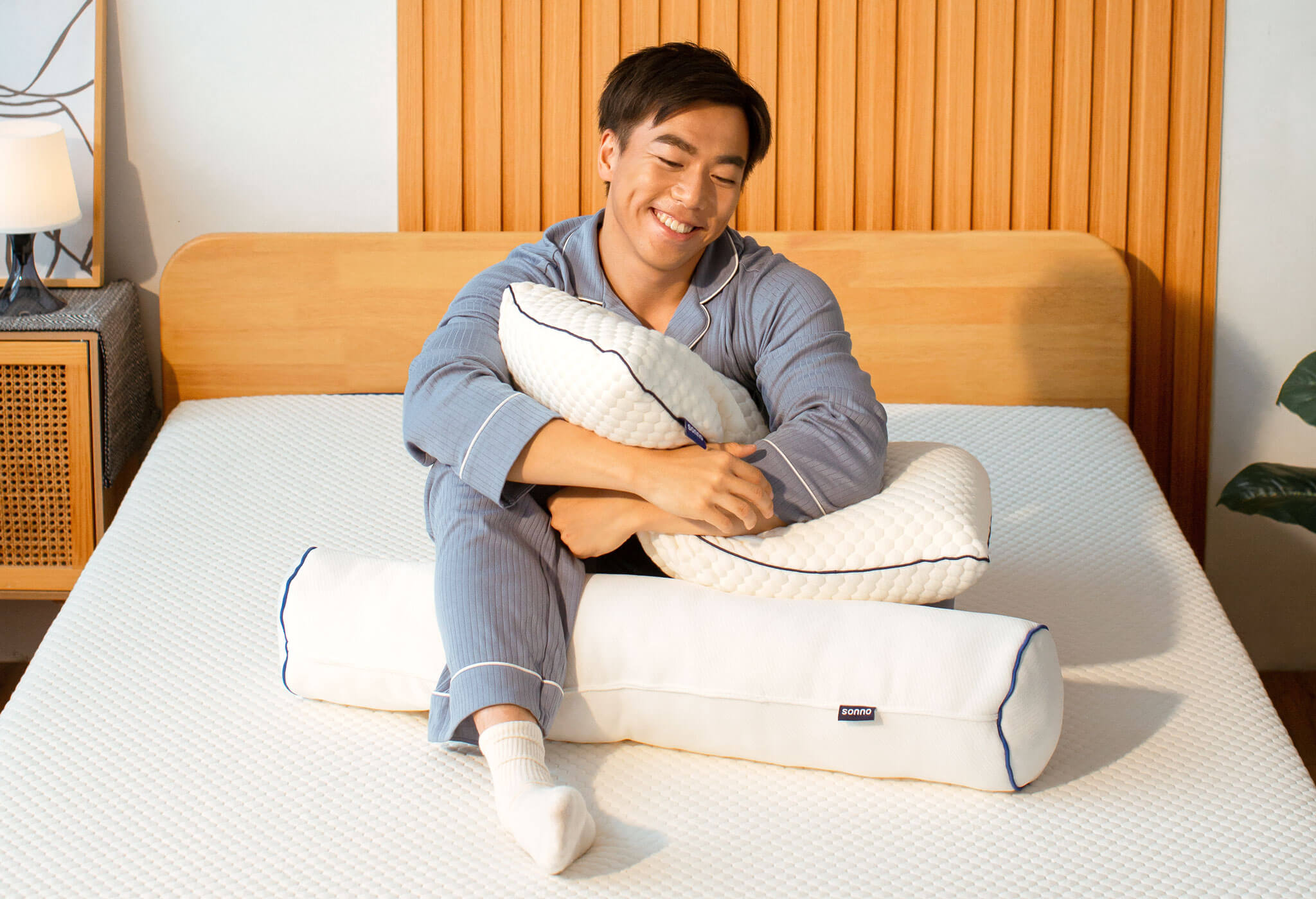 Happy Man hugging Sonno the Pillow on Sonno Original Mattress